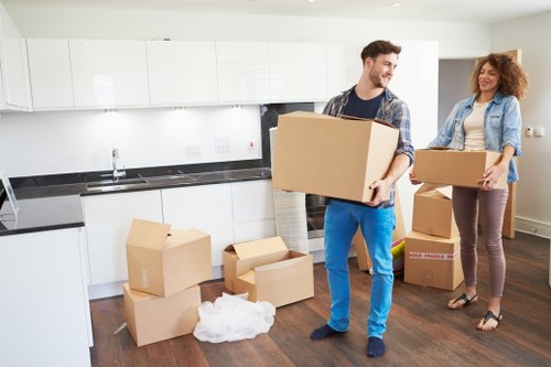 Local removals crew handling boxes in a central London apartment building